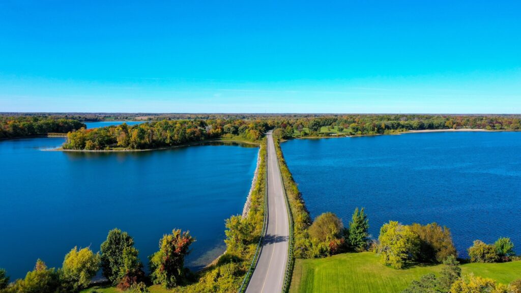 Aerial view of the Long Sault Parkway featuring body of water and singular road connecting land masses.