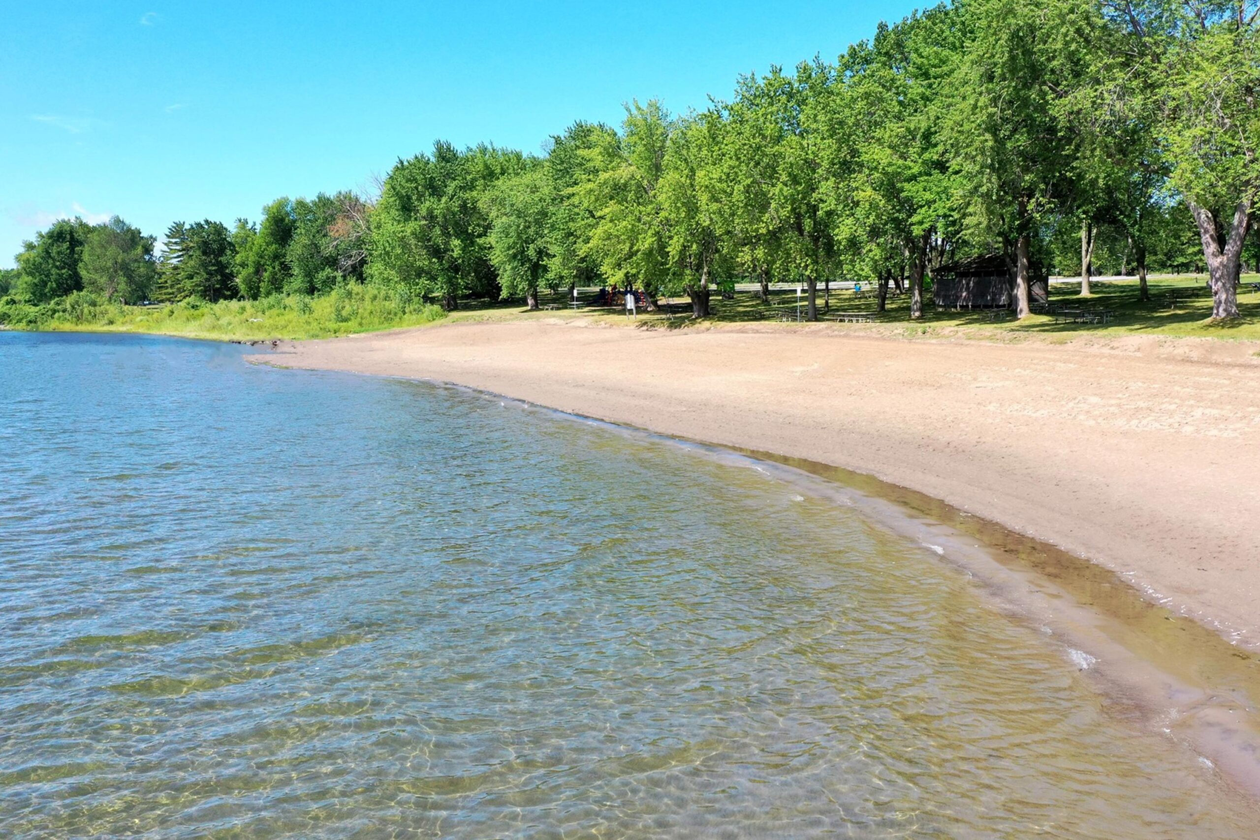 Mille Roches beach with sand and luscious green trees.