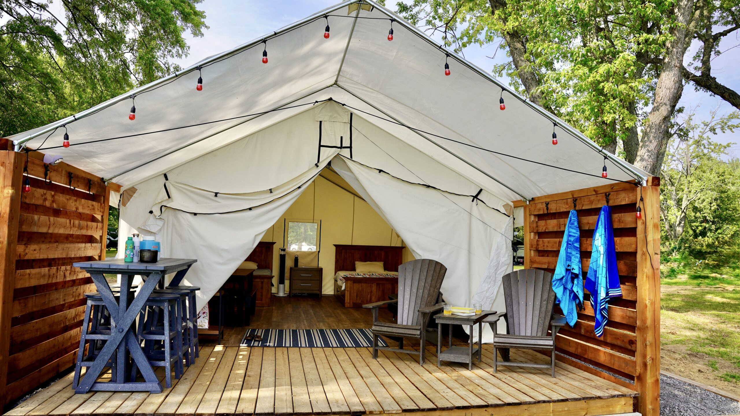 Prospector tent consisting of canvas like material with interior preview of rustic furniture.